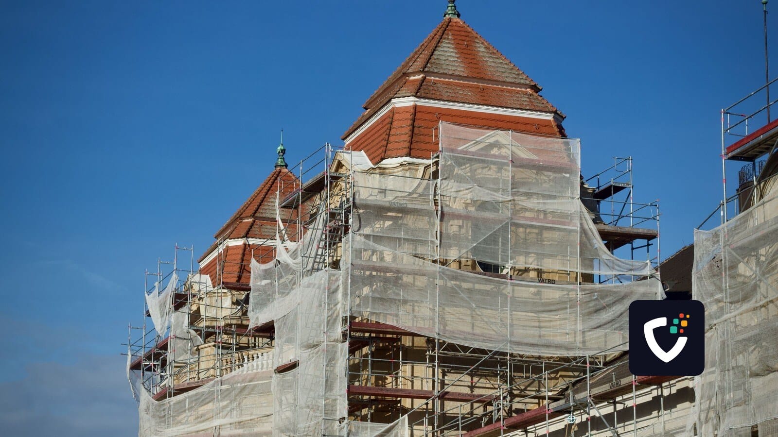 A historic building under restoration, covered in scaffolding and protective nets