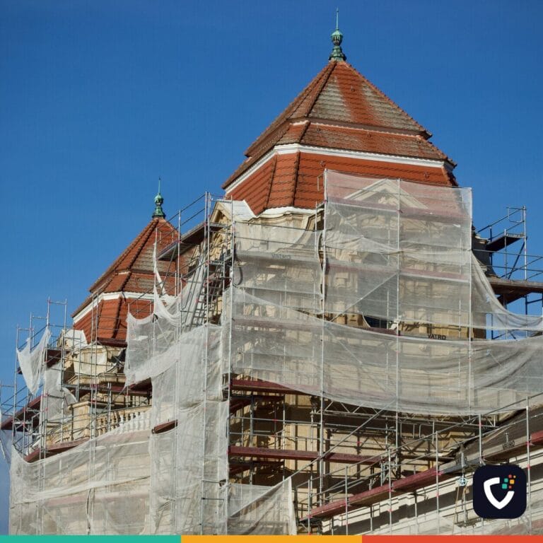 A historic building under restoration, covered in scaffolding and protective nets