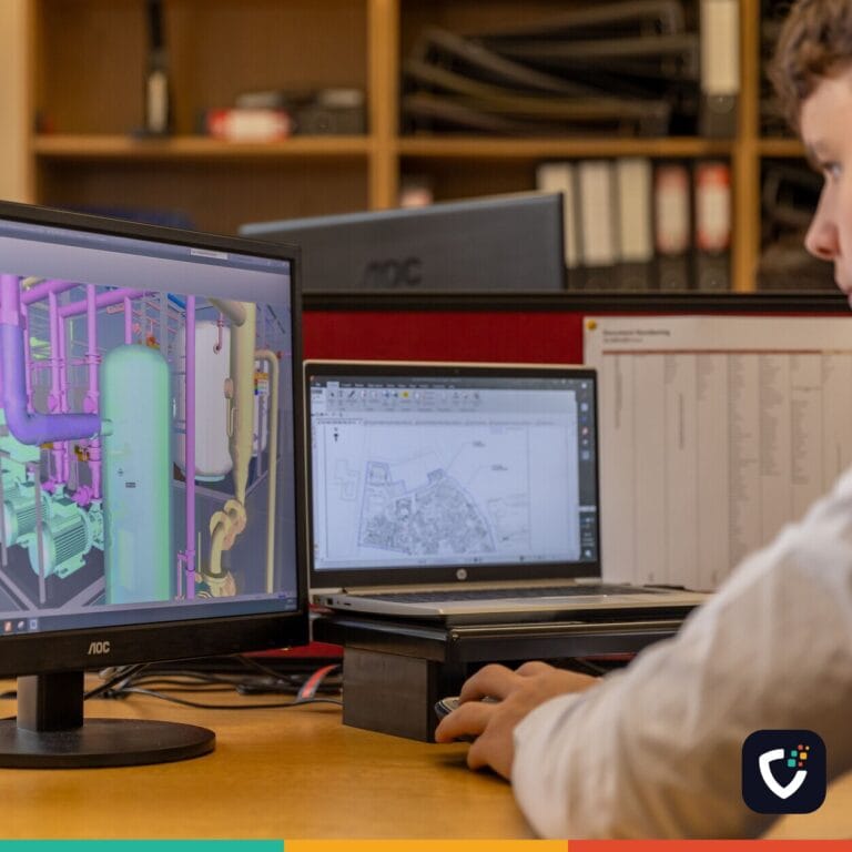 Engineer working with CAD software on dual monitors in an office setting