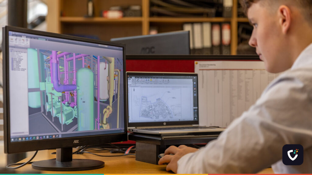 Engineer working with CAD software on dual monitors in an office setting