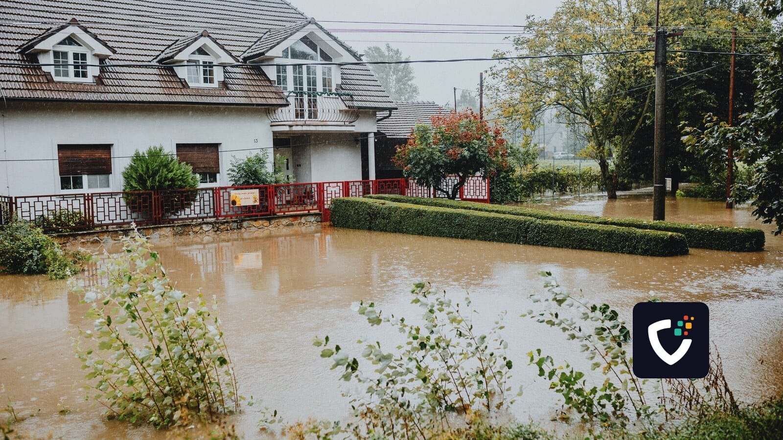 A suburban house surrounded by floodwaters after heavy rain, showing impact of natural disaster