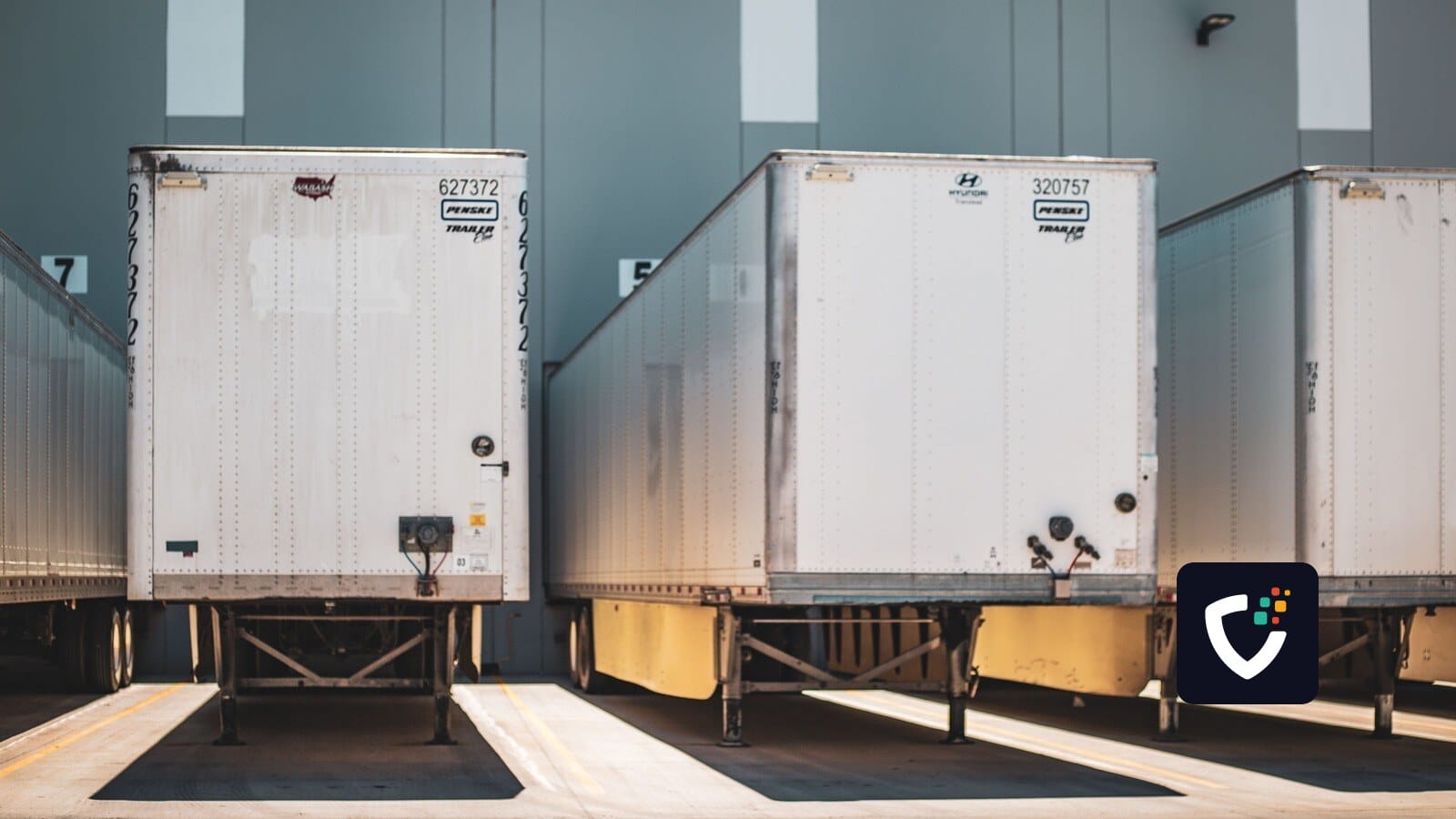 A row of freight trailers parked at a commercial loading dock, emphasizing transportation and logistics