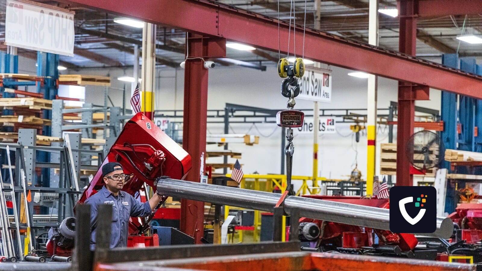 Worker operating heavy machinery in a factory, moving steel bars. Industrial scene indoors