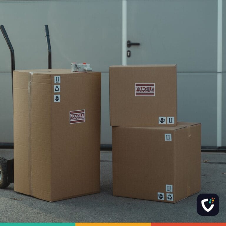 Three cardboard boxes on a dolly, ready for shipping outside a warehouse
