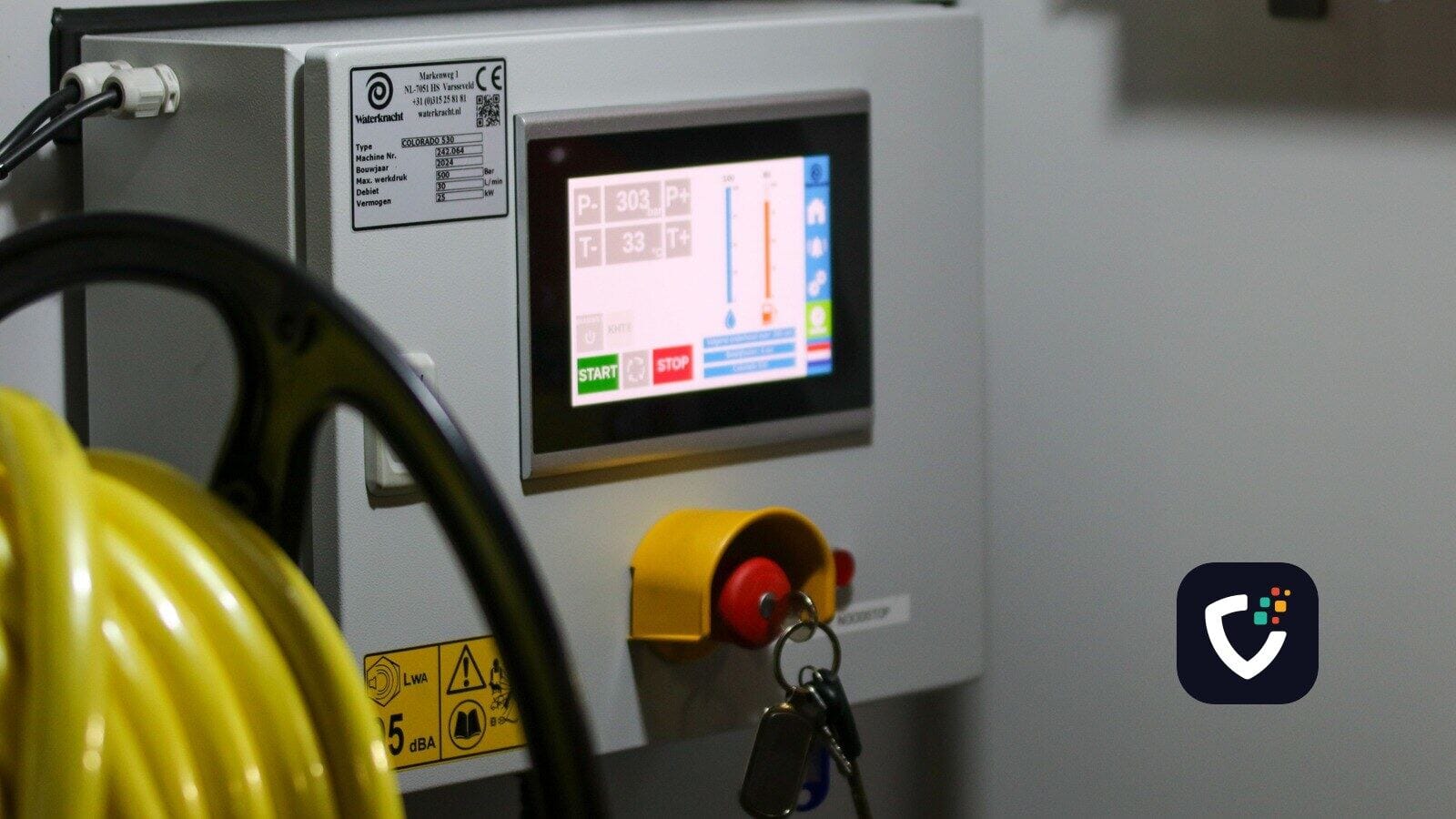 An industrial machine's control cabinet, with a small colour touchscreen, an emergency stop button and a key switch.