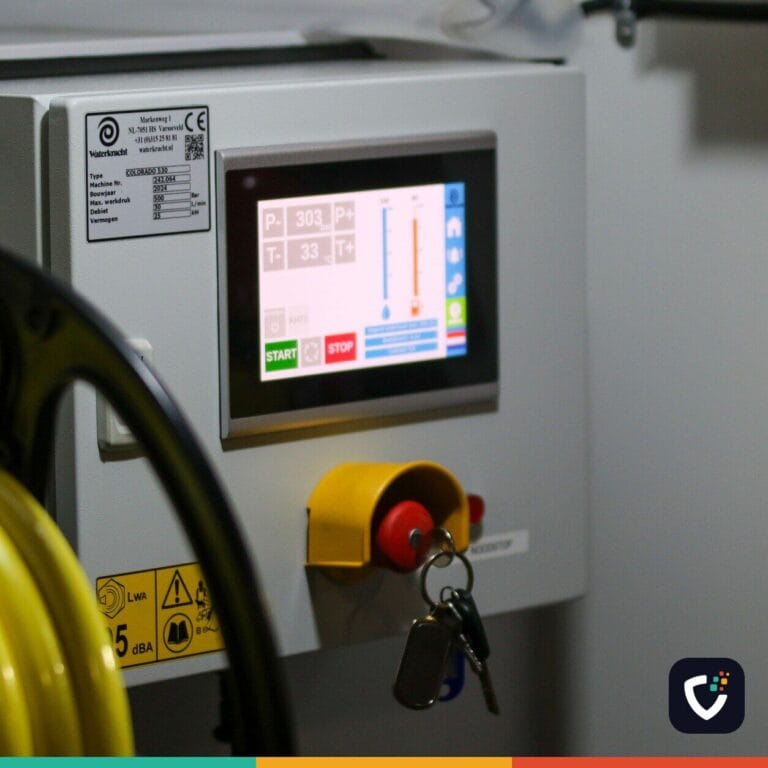 An industrial machine's control cabinet, with a small colour touchscreen, an emergency stop button and a key switch.