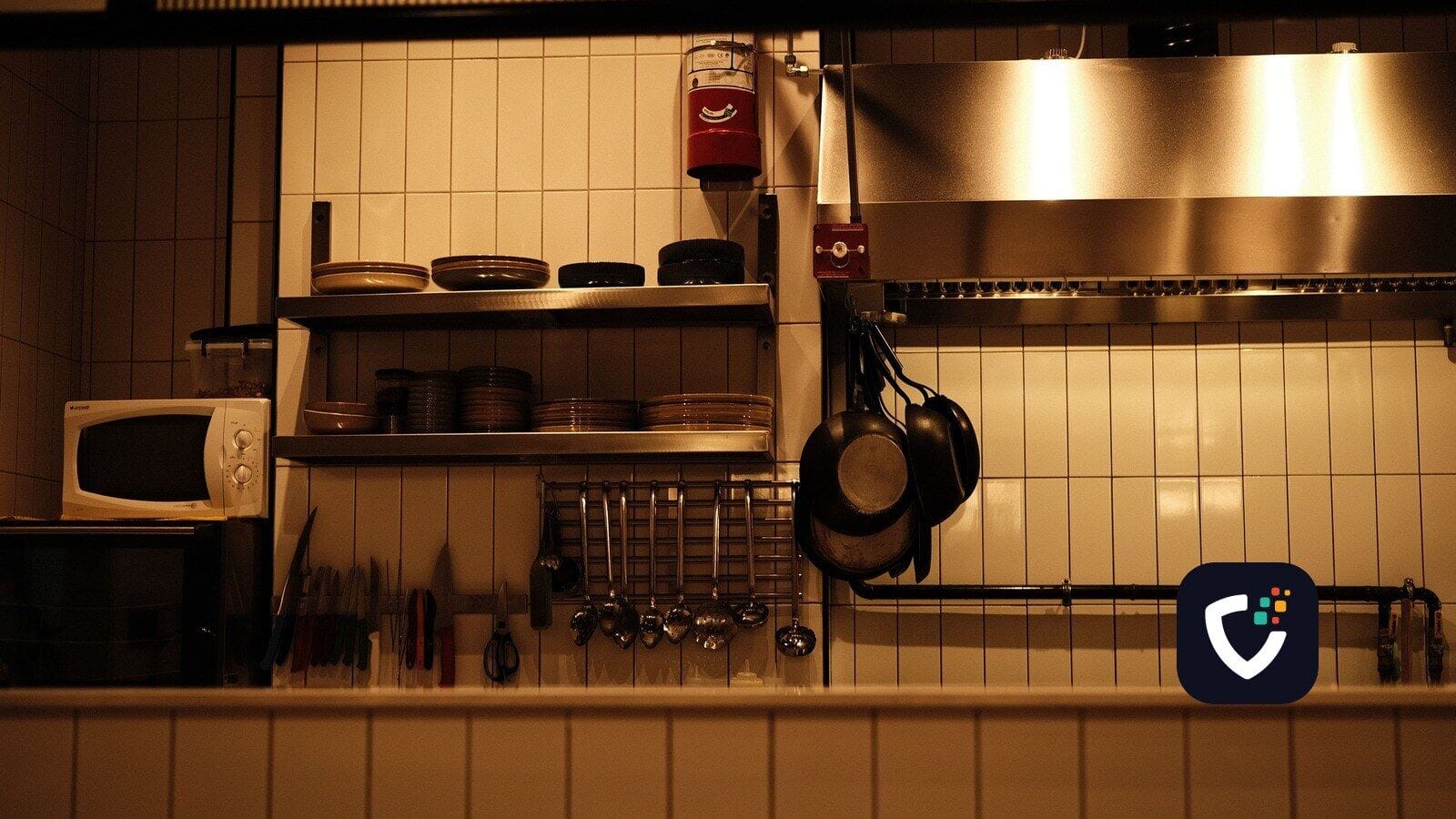 A tidy, fully equipped commercial kitchen with the lights on and nobody working in it.