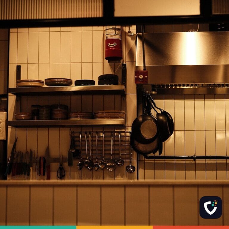 A tidy, fully equipped commercial kitchen with the lights on and nobody working in it.