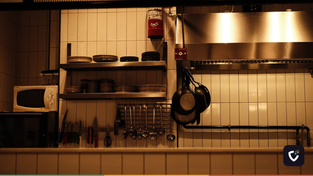 A tidy, fully equipped commercial kitchen with the lights on and nobody working in it.