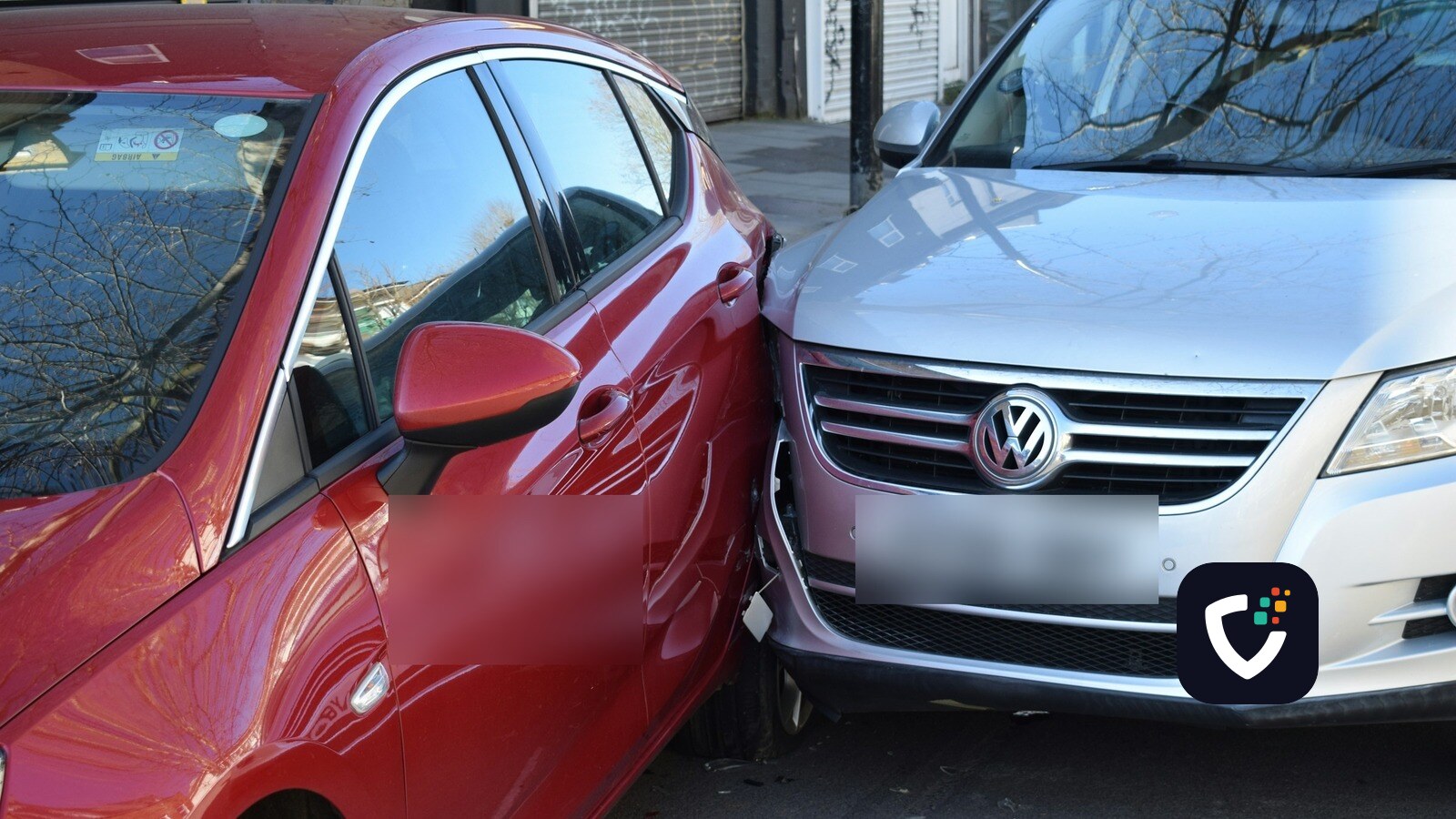 A red hatchback and a silver SUV pressed together after a low-speed collision on a city street.