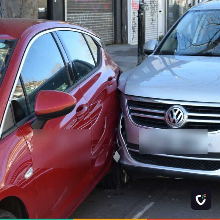 A red hatchback and a silver SUV pressed together after a low-speed collision on a city street.