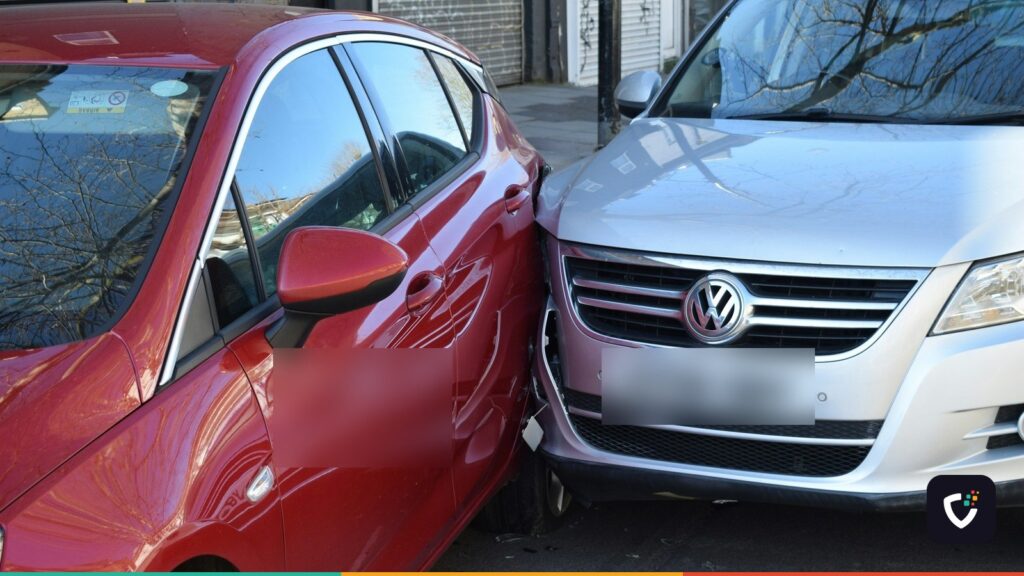 A red hatchback and a silver SUV pressed together after a low-speed collision on a city street.